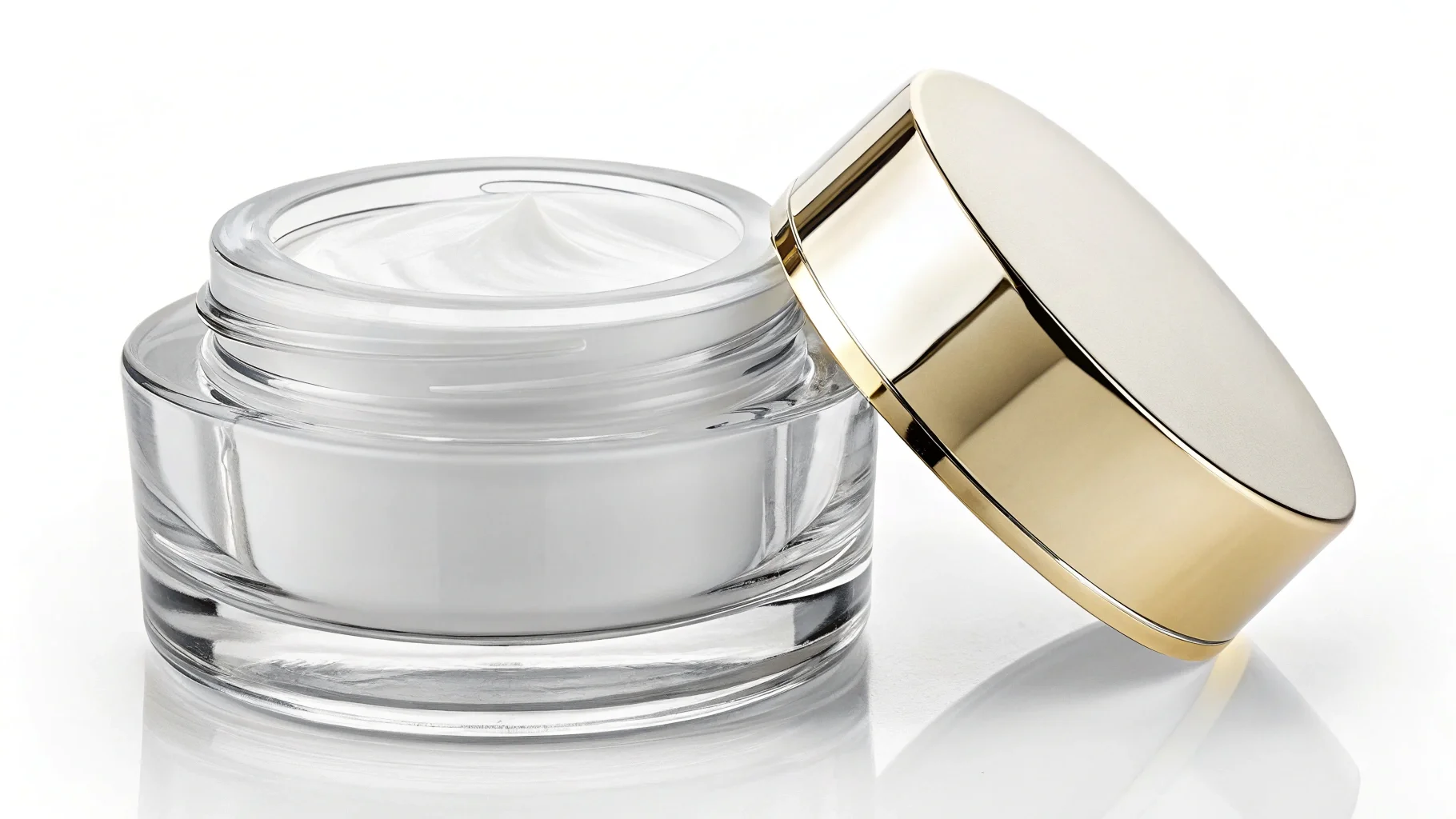 Close-up of a thick-walled, clear glass cosmetic jar.